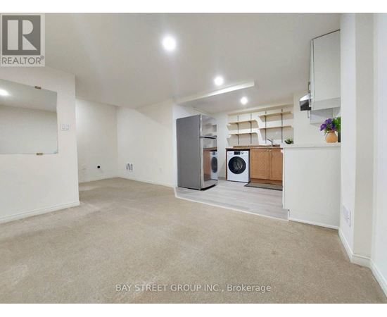 A spacious, empty room with a washer and dryer in it.