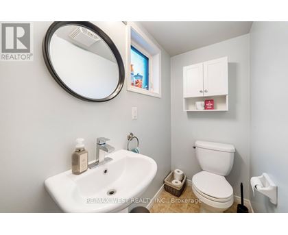 A bathroom with a sink, toilet, and a mirror.