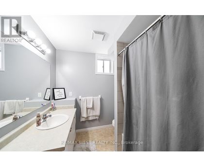 A bathroom with a sink, mirror, and shower curtain.