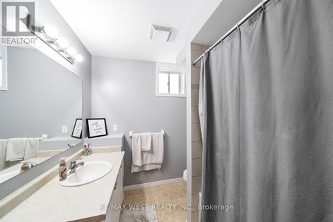 A bathroom with a sink, mirror, and shower curtain.