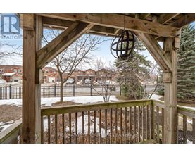 A wooden gazebo with a metal fence in the background.