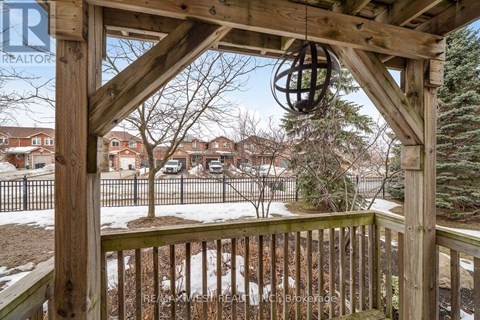 A wooden gazebo with a metal fence in the background.