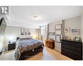 A bedroom with a bed, nightstand, and dresser.