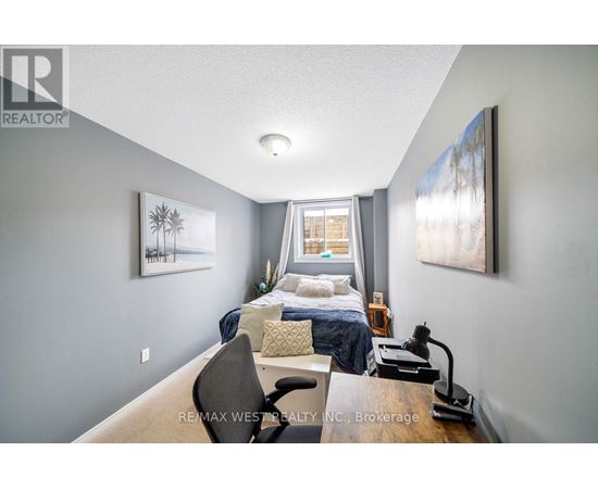 A bedroom with a bed, chair, and two pictures on the wall.