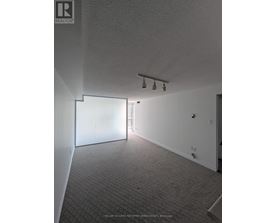 A room with a carpeted floor and a white wall.