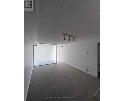A room with a carpeted floor and a white wall.