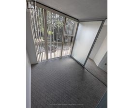 A room with a carpeted floor and a glass door leading to a balcony.