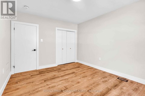 A room with wooden flooring and two white doors.