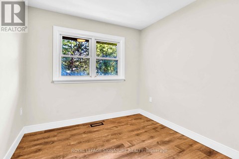 A room with a window showing trees outside.
