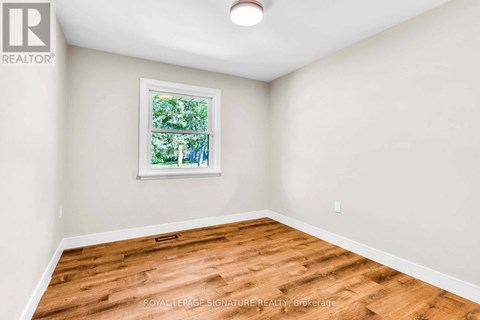 A room with a window and wooden flooring.