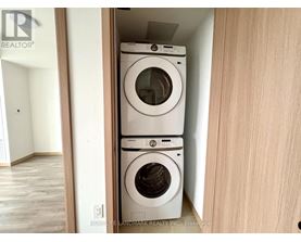A stack of two white washing machines in a small space.