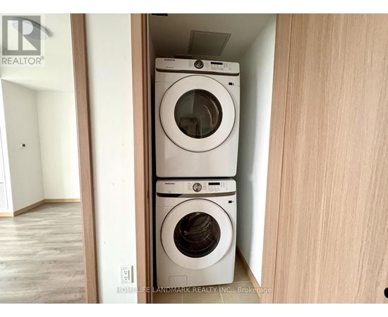 A stack of two white washing machines in a small space.