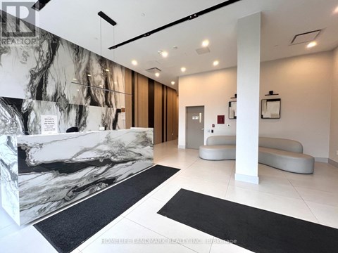 A reception area with a marble wall and black and white rugs.