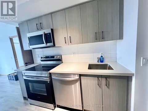 A modern kitchen with a stainless steel sink and a microwave above it.