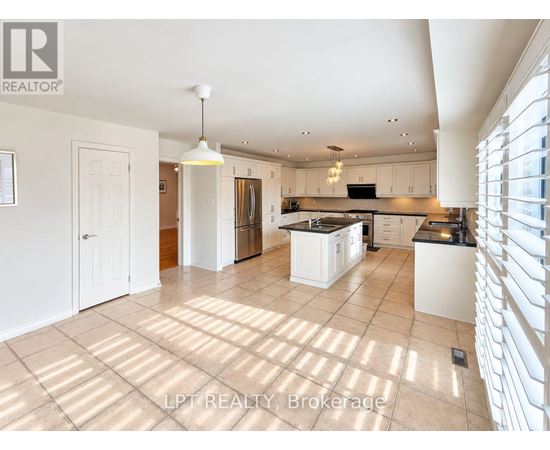 A spacious kitchen with white cabinets and a large island.