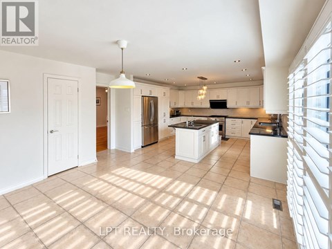 A spacious kitchen with white cabinets and a large island.