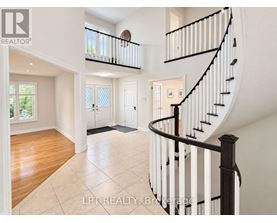 A spacious interior of a house with a curved staircase.