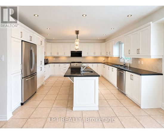 A kitchen with white cabinets and a black countertop.