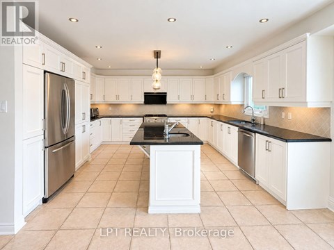 A kitchen with white cabinets and a black countertop.