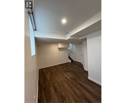 A room with wooden flooring and white walls.
