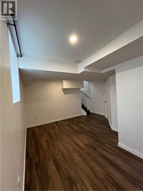 A room with wooden flooring and white walls.