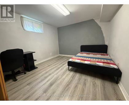 A bedroom with a bed, desk, and chair.