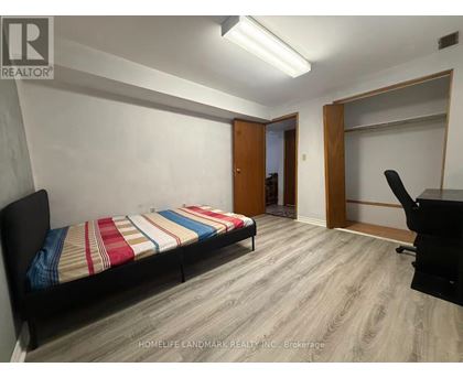 A bedroom with a bed, desk, and chair.
