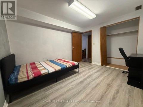 A bedroom with a bed, desk, and chair.