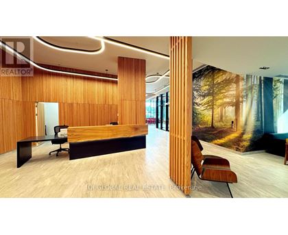 A modern office space with a wooden reception desk and a large mural on the wall.