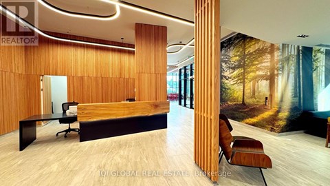 A modern office space with a wooden reception desk and a large mural on the wall.
