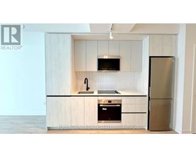 A kitchen with a refrigerator, microwave, and oven.