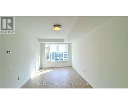 A room with a window and a wooden floor.
