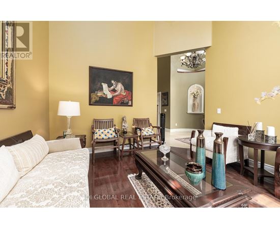 A living room with a couch, chairs, and a painting on the wall.