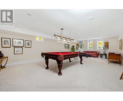 A room with a pool table and a red couch.