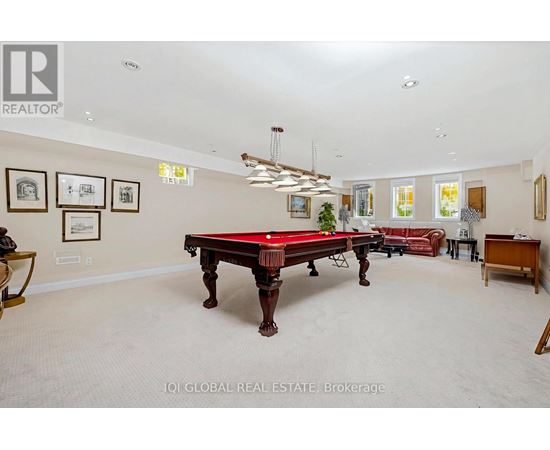 A room with a pool table and a red couch.