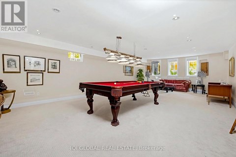 A room with a pool table and a red couch.