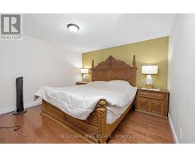 A bedroom with a bed, nightstand, and lamp.