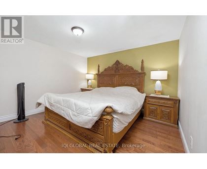 A bedroom with a bed, nightstand, and lamp.