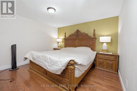 A bedroom with a bed, nightstand, and lamp.