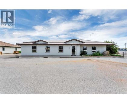 A white building with a brown roof and a sign that says REALTOR.