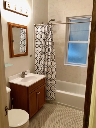 A bathroom with a toilet, sink, and shower.