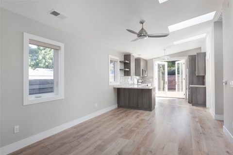 A spacious kitchen with a bar area and a ceiling fan.