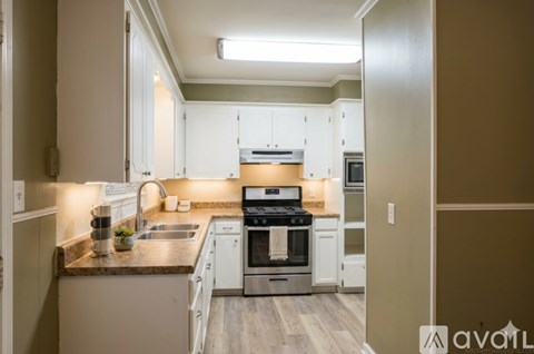 A kitchen with white cabinets and a stainless steel oven.