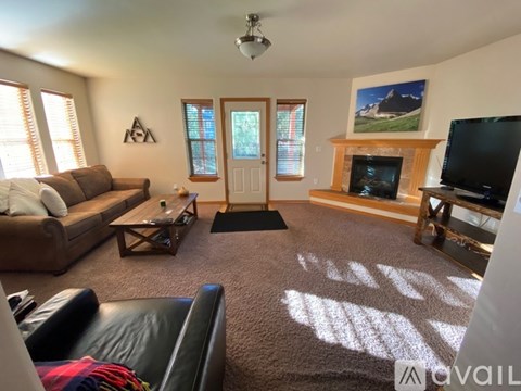 A living room with a couch, a coffee table, and a television.