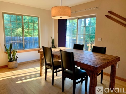 A dining room with a wooden table and chairs.