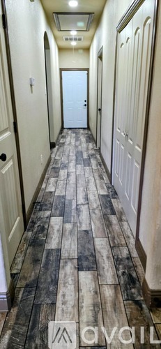 A long hallway with a checkered floor and white walls.