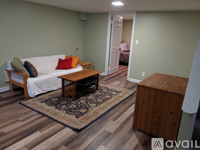 A living room with a white couch and a wooden coffee table.