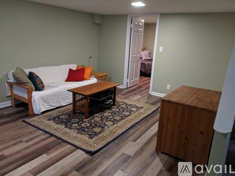 A living room with a white couch and a wooden coffee table.
