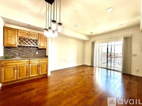 A spacious kitchen with wooden cabinets and a stone backsplash.