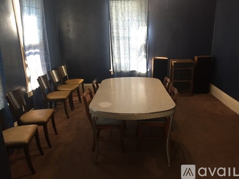 A dining room with a table and chairs.